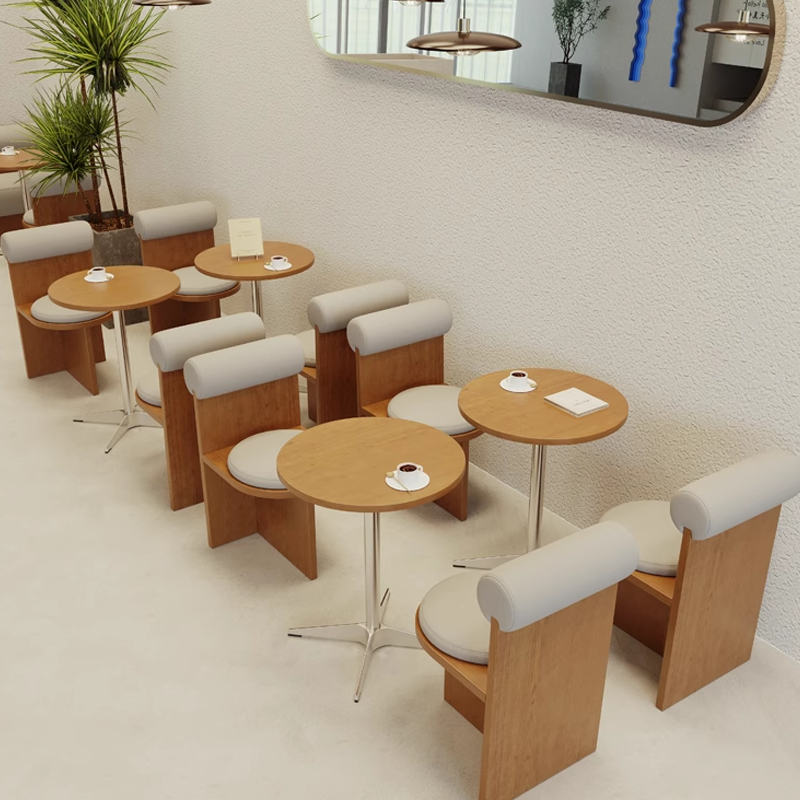 Coffee shop interior showcasing round and square wooden tables with comfortable chairs for a casual dining experience.