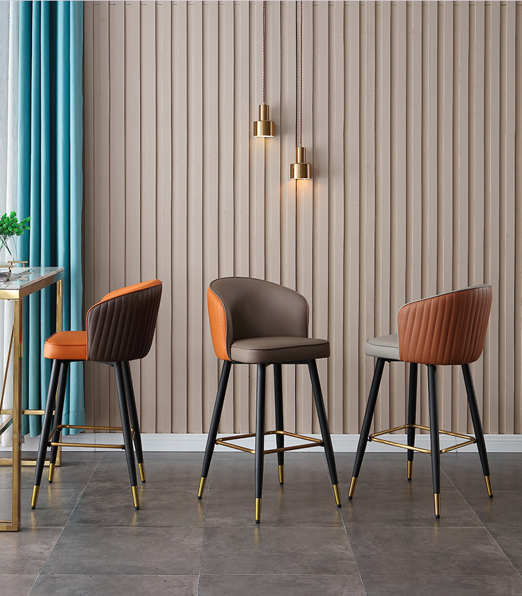 Set of three modern bar stools in orange, brown, and gray colors with black metal frames and golden footrests, ideal for contemporary kitchens.