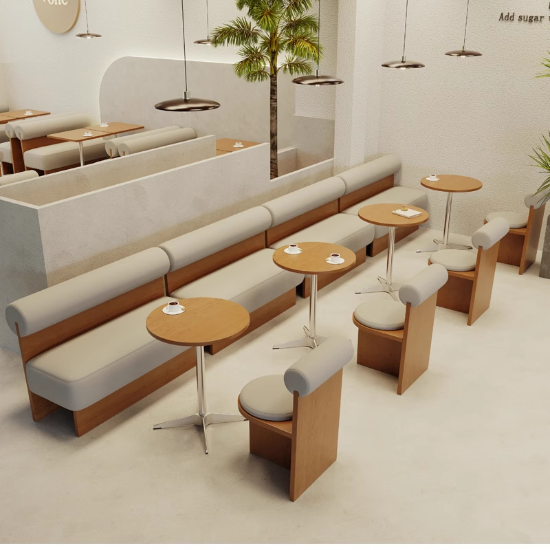 A contemporary cafe space with light wooden tables and comfortable seating, creating a relaxed and modern environment.