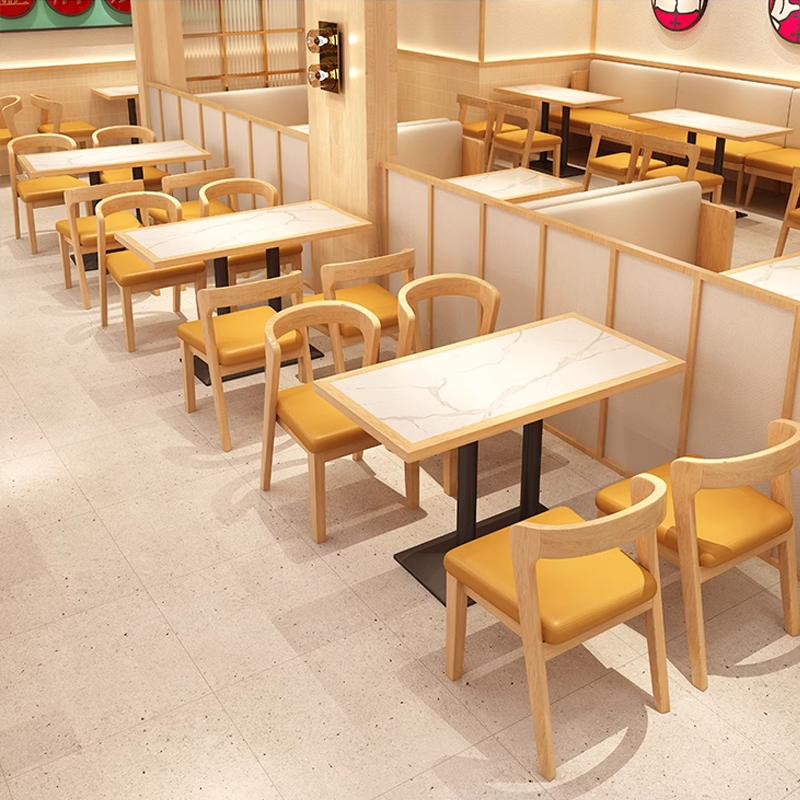 Cozy restaurant dining area with yellow cushioned chairs and marble tables.