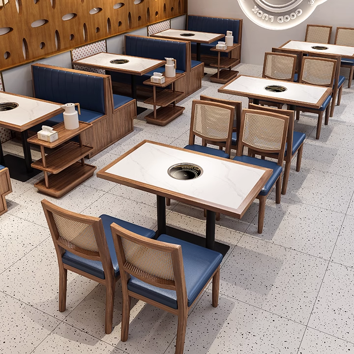 Dining room restaurant with tables and chairs featuring a combination of blue vinyl seats and ratten backs. 