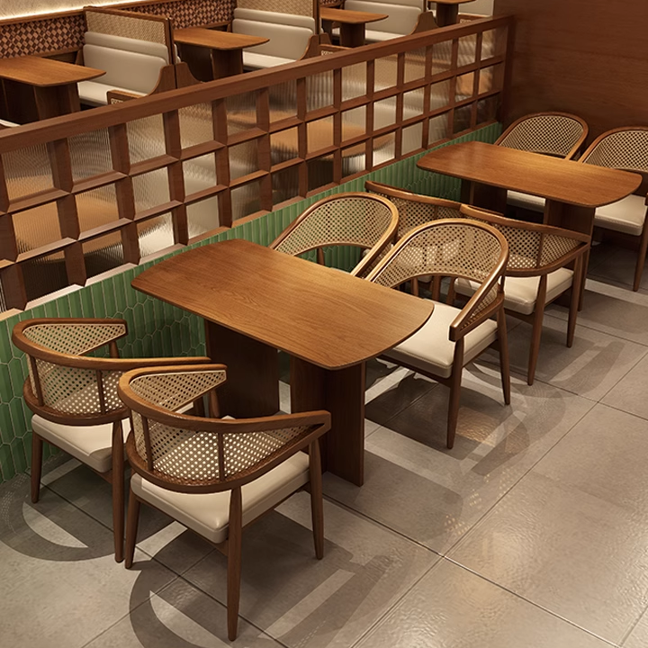 Modern cane chairs with wooden frames and cushioned seats placed around square wooden tables in a restaurant setting.