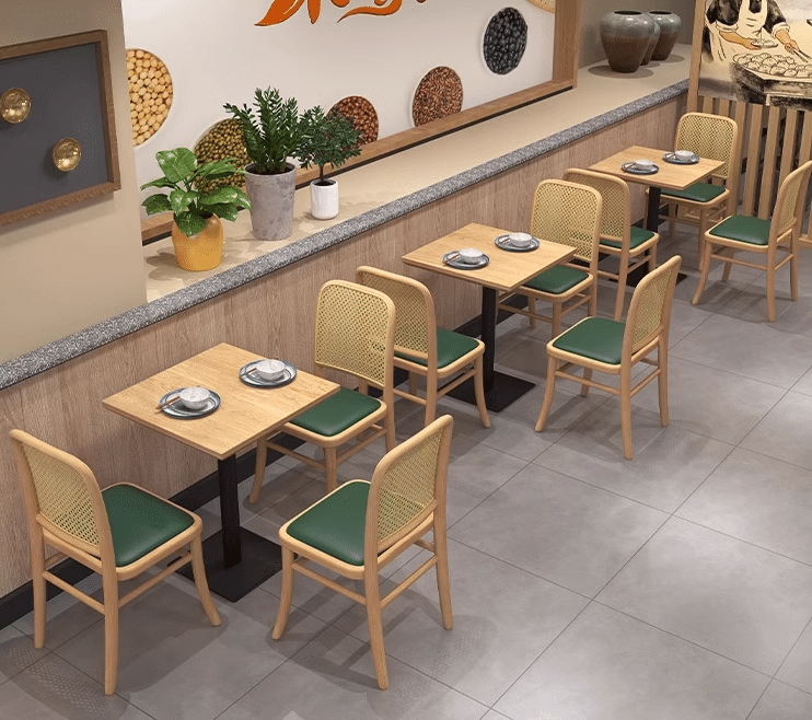 Minimalist wooden dining chairs and tables with green seating in a modern restaurant, showcasing a clean design and casual ambiance.