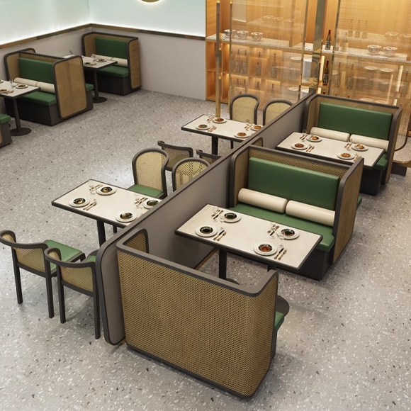 Modern restaurant dining booths with green cushions and cane-back chairs, marble tables with dishes and chopsticks, and elegant decor.