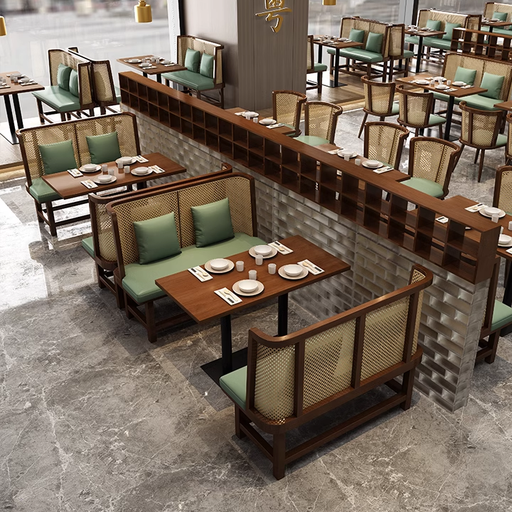 Modern dining setup with wooden cane chairs, green cushions, and a marble floor.