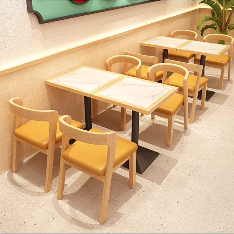 Modern restaurant seating with yellow leather chairs and marble-top tables.