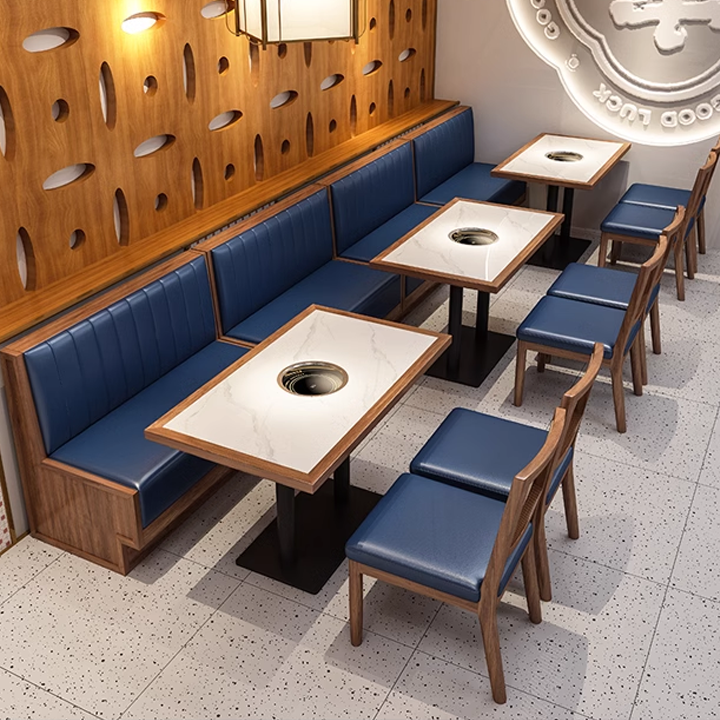 Restaurant dining area with blue seating booths and wooden tables, featuring circular holes in the wall design.