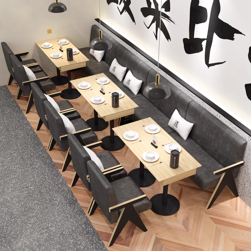 A modern restaurant interior with gray cushioned chairs, wooden tables, and wall decor.