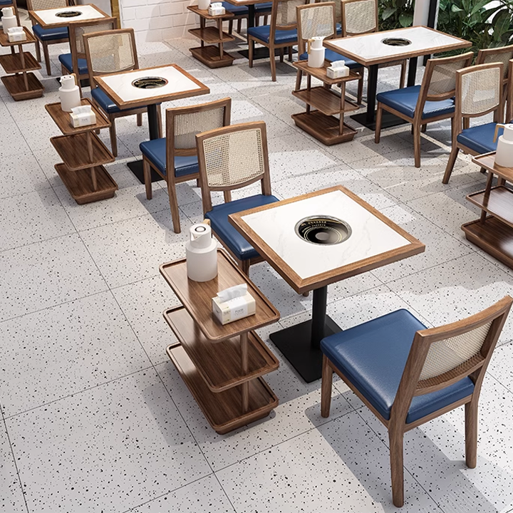 Dining tables with wooden chairs featuring cane backs and blue cushions in a contemporary restaurant.