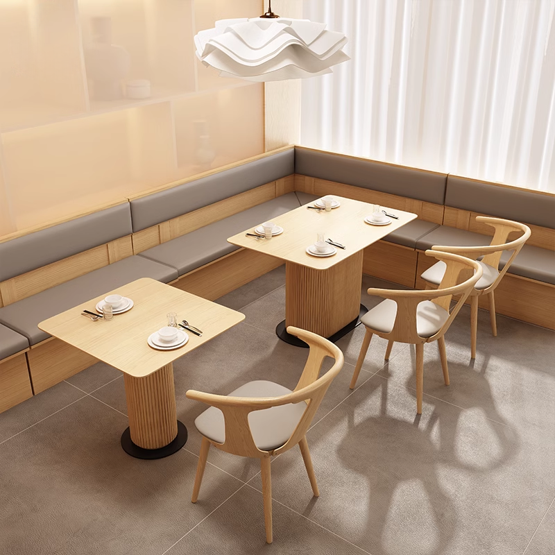 A round wooden-rimmed rock slab dining table in a light, modern interior with clean lines and contemporary chairs.