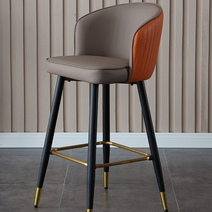 Elegant leather bar stool with a combination of brown and orange upholstery, black legs, and gold footrests.