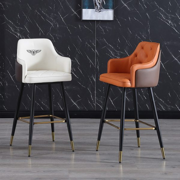 Two stylish barstools with brown and white leather seat and backrest, black steel legs with gold foot caps.