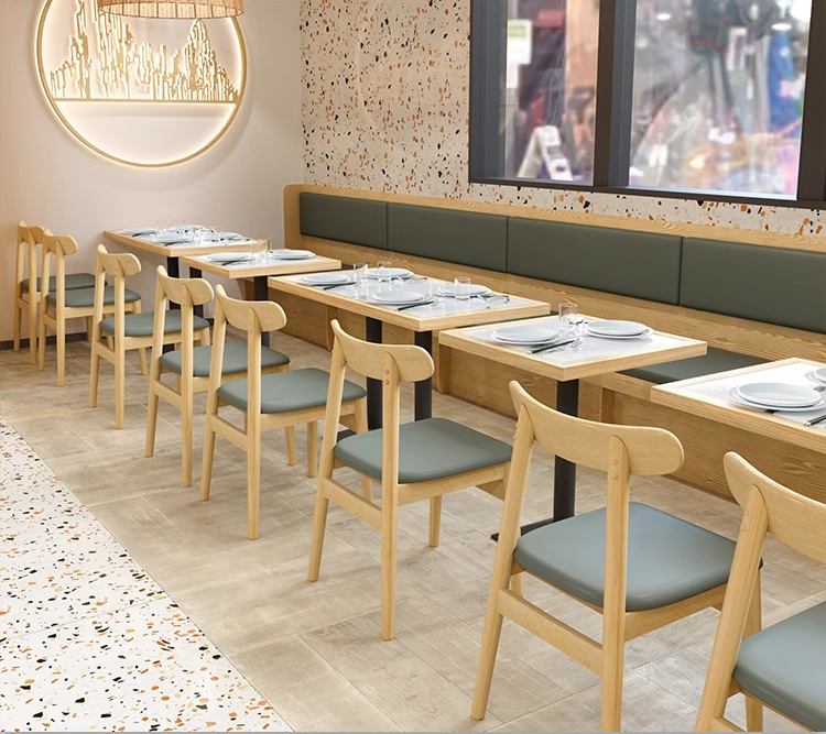 Modern dining setup with wooden-edged rock slab tables and grey seating in a restaurant interior.